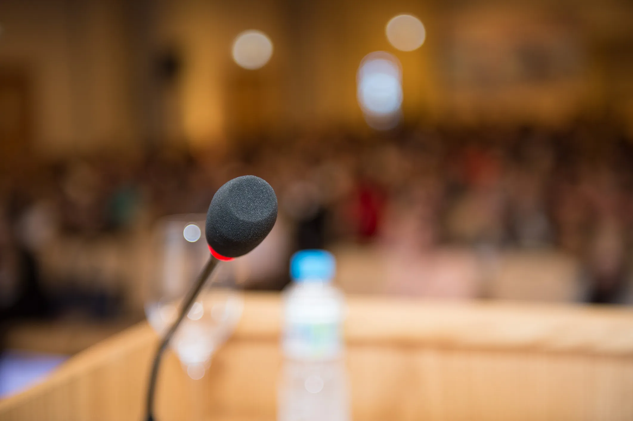 Microphone in front of blurred audience at press event 