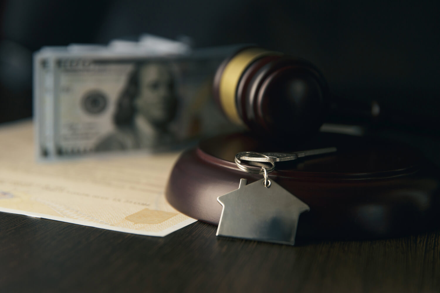 Gavel, house key, and cash representing construction lien waivers and legal support.