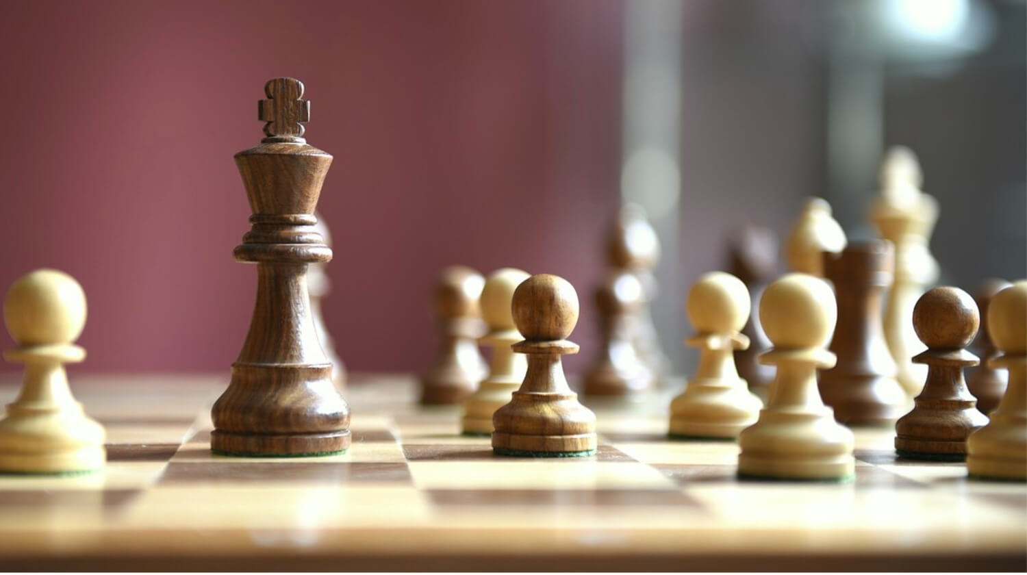 Chess pieces on a board, focusing on the king.