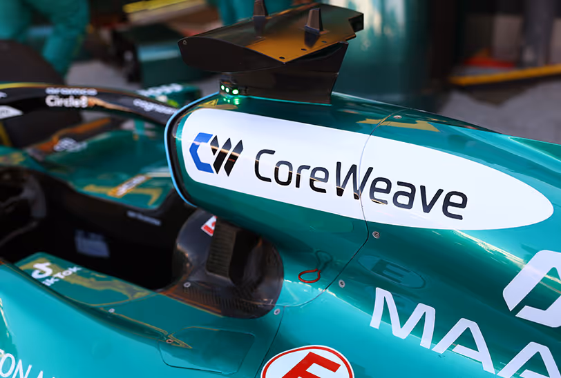 Close-up of the Aston Martin Aramco F1 car featuring the CoreWeave logo on its teal bodywork near the cockpit.