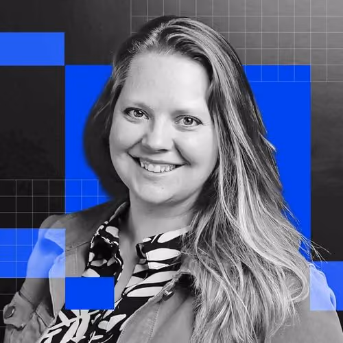 Smiling woman with long hair wearing a patterned blouse and jacket against a background with blue shapes.