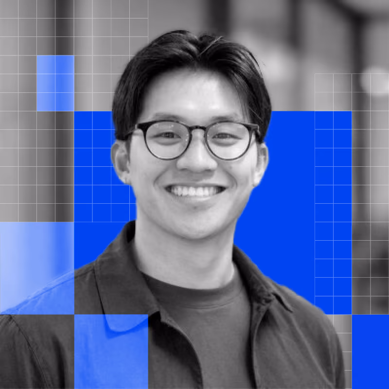 Smiling young man with glasses wearing a collared shirt, with blue digital design overlays.