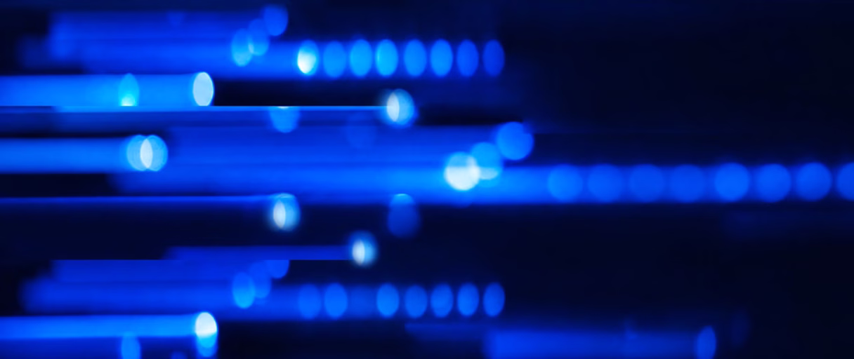 Abstract blue light streaks and dots on a dark background creating a tech-inspired pattern.