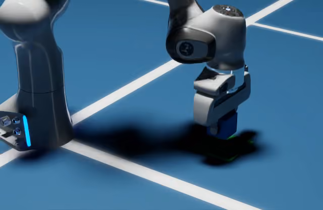 Franka arm placing a blue cube on a green target, viewed from a low camera angle beside the robot base