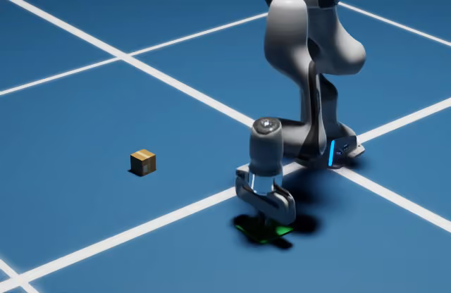 Franka arm placing an object on a green target with a small cardboard carton in the scene