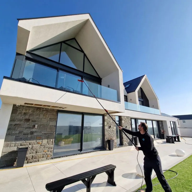 Eco Green team member cleaning large windows in Porthcawl