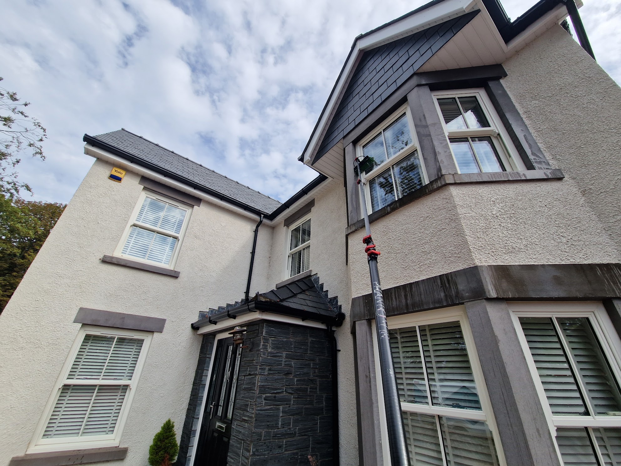 Eco Green window cleaner using the pure water fed pole system on a home near Brackla