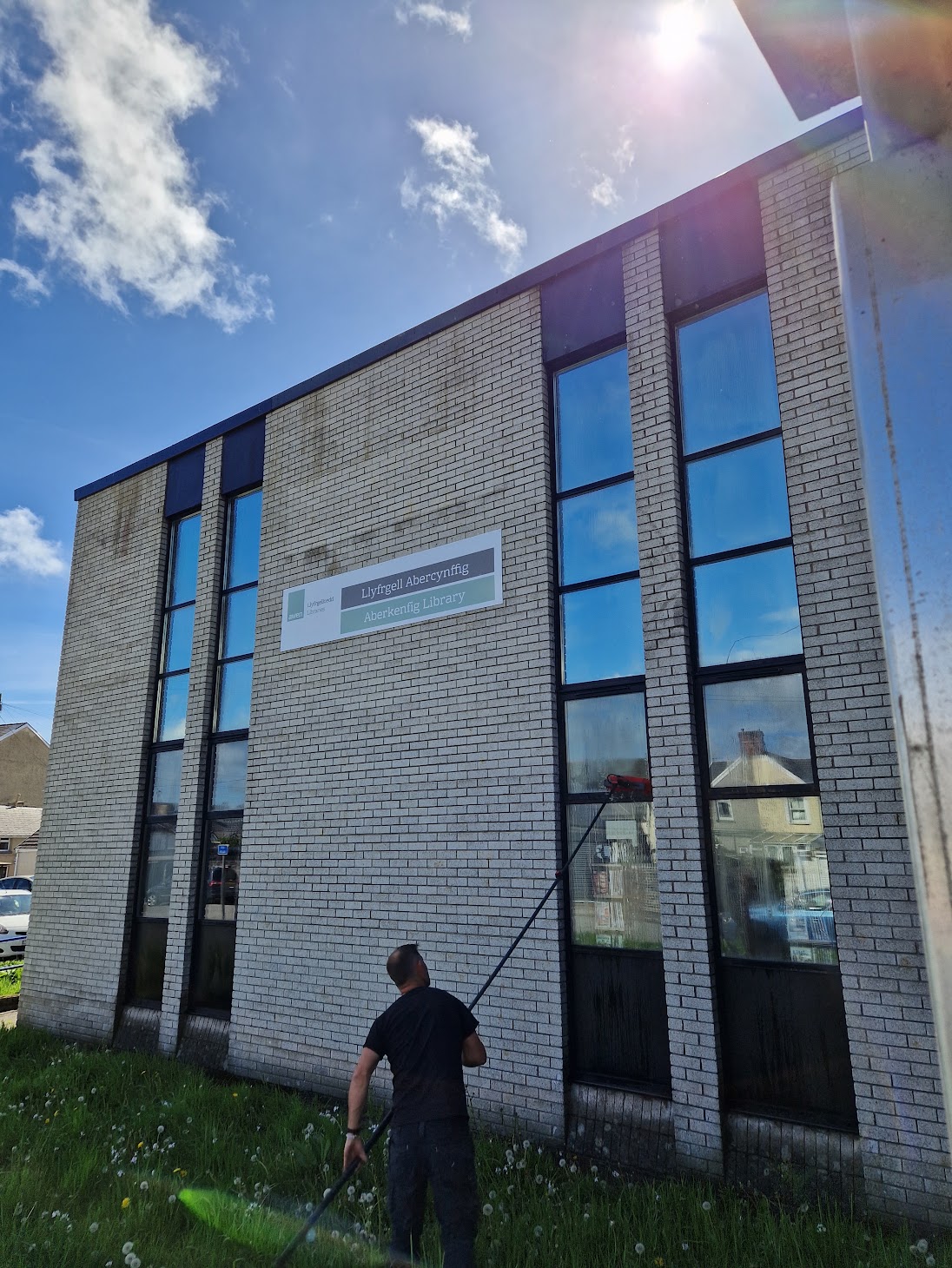 Eco Green team window cleaning a home in Bridgend