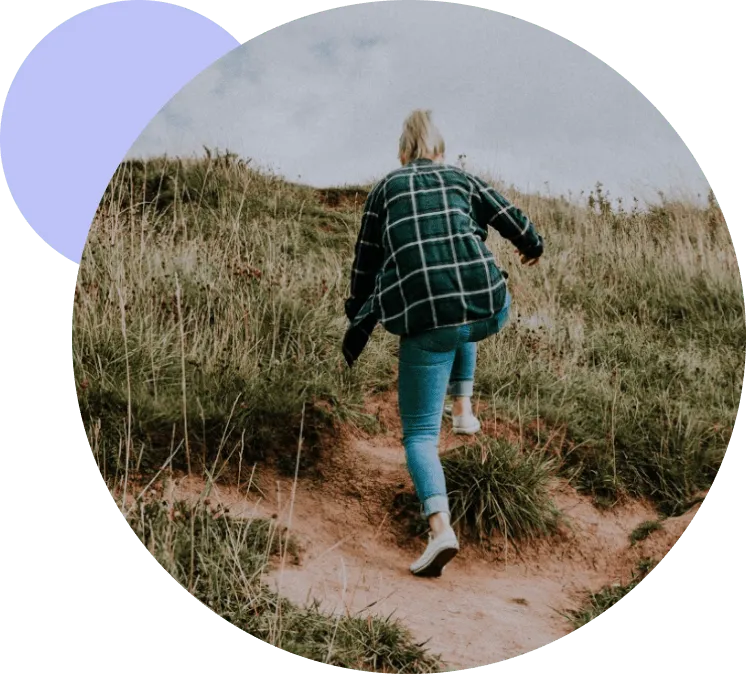 Person hiking up hill in jeans
