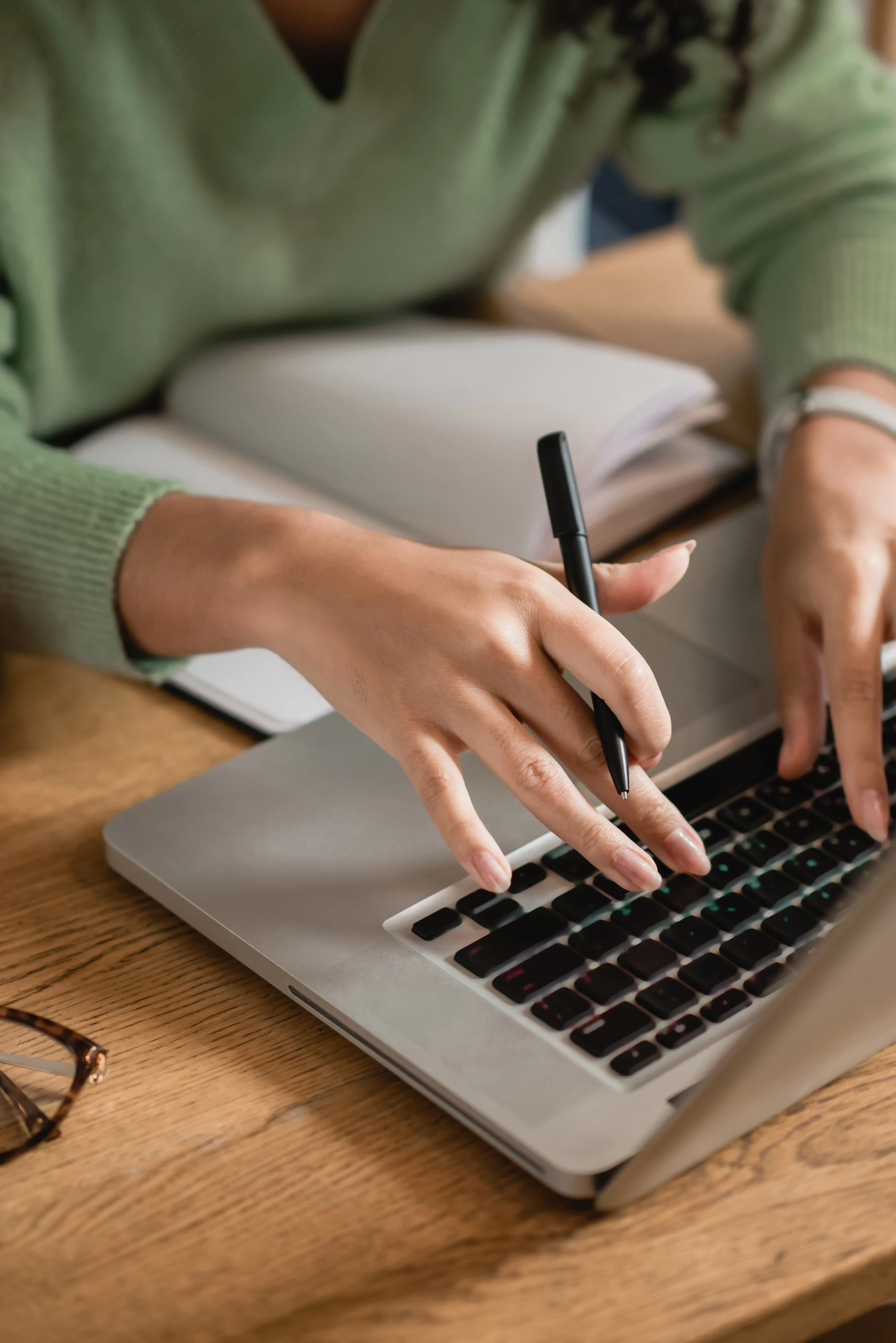 person using laptop with pen
