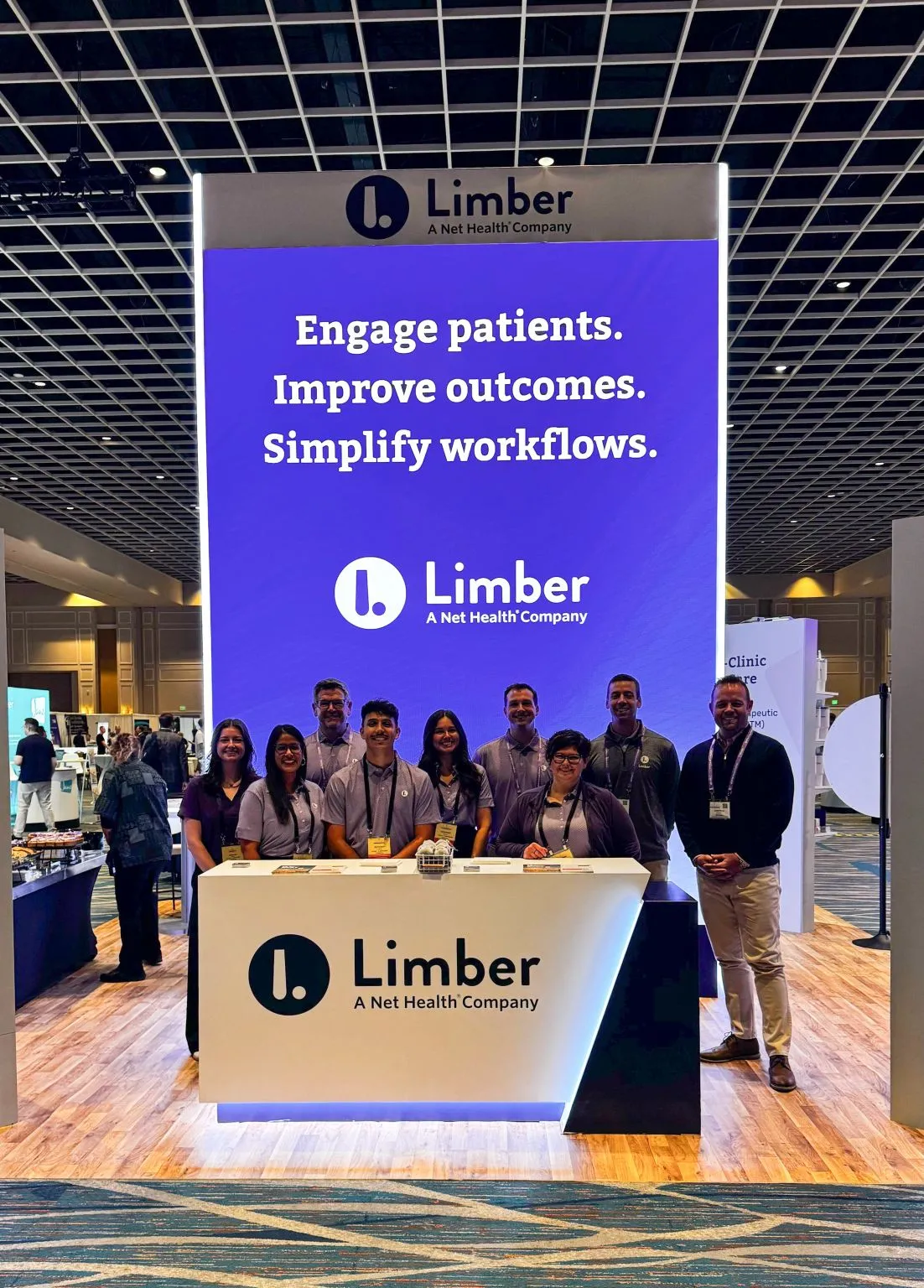 The Limber Health team smiling in front of the Limber booth at a rehab therapy conference