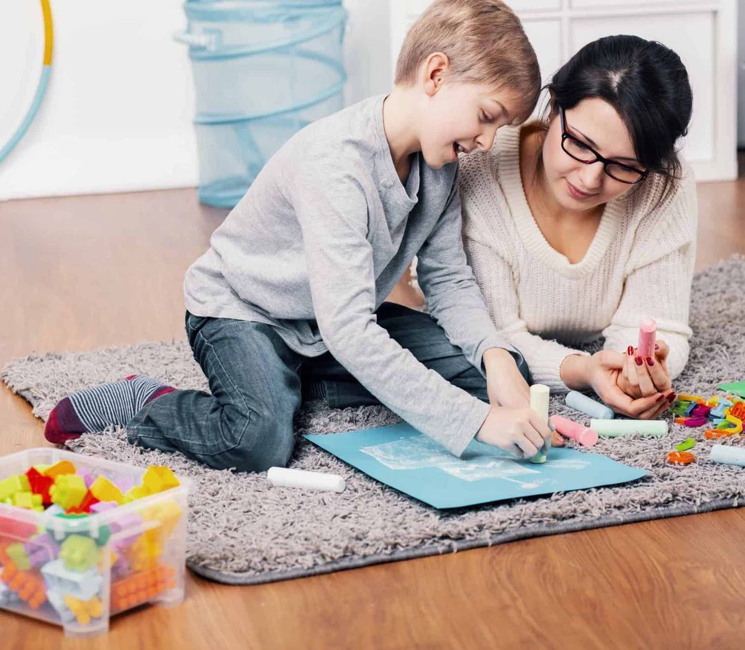 child and aba therapist sitting together