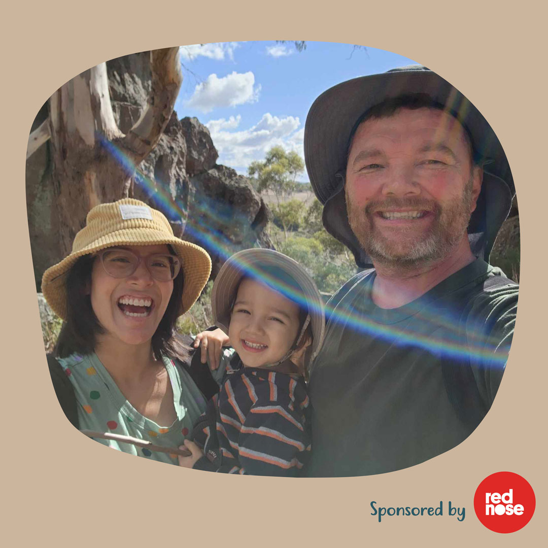 Kim, her partner and second child pose for a photo with a rainbow.