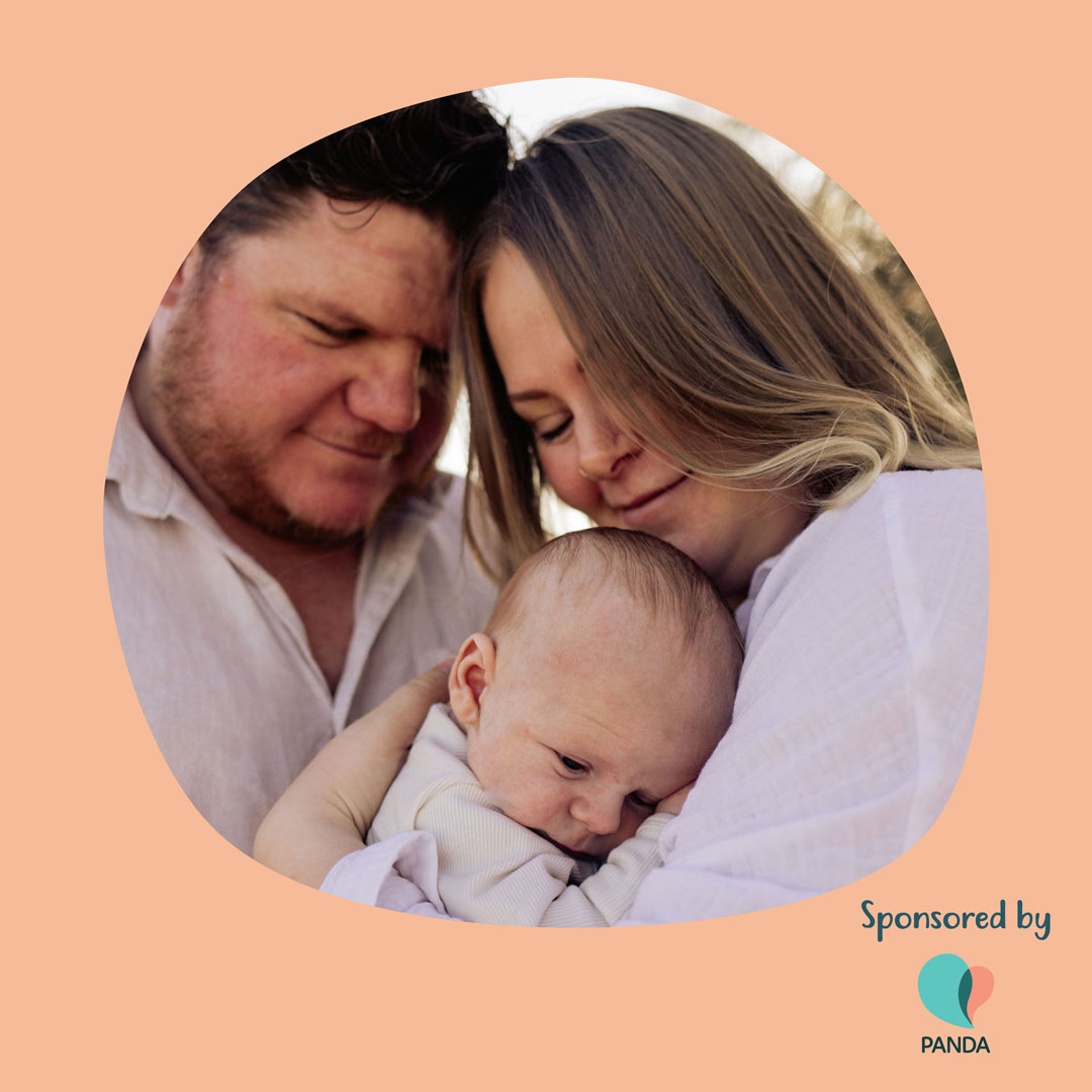Emily and her husband hold their newborn baby.