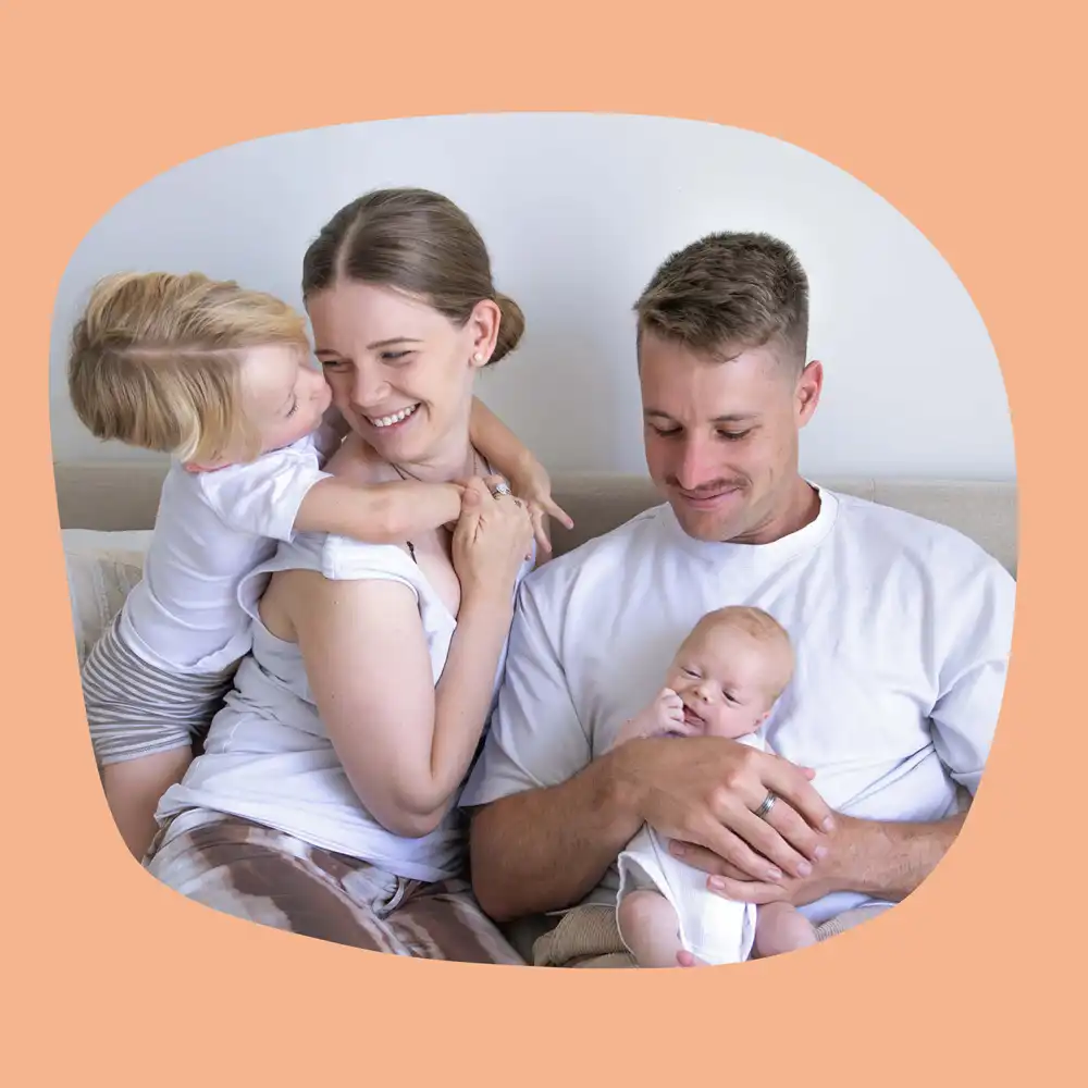 Laura poses for a photo with her husband and two children.