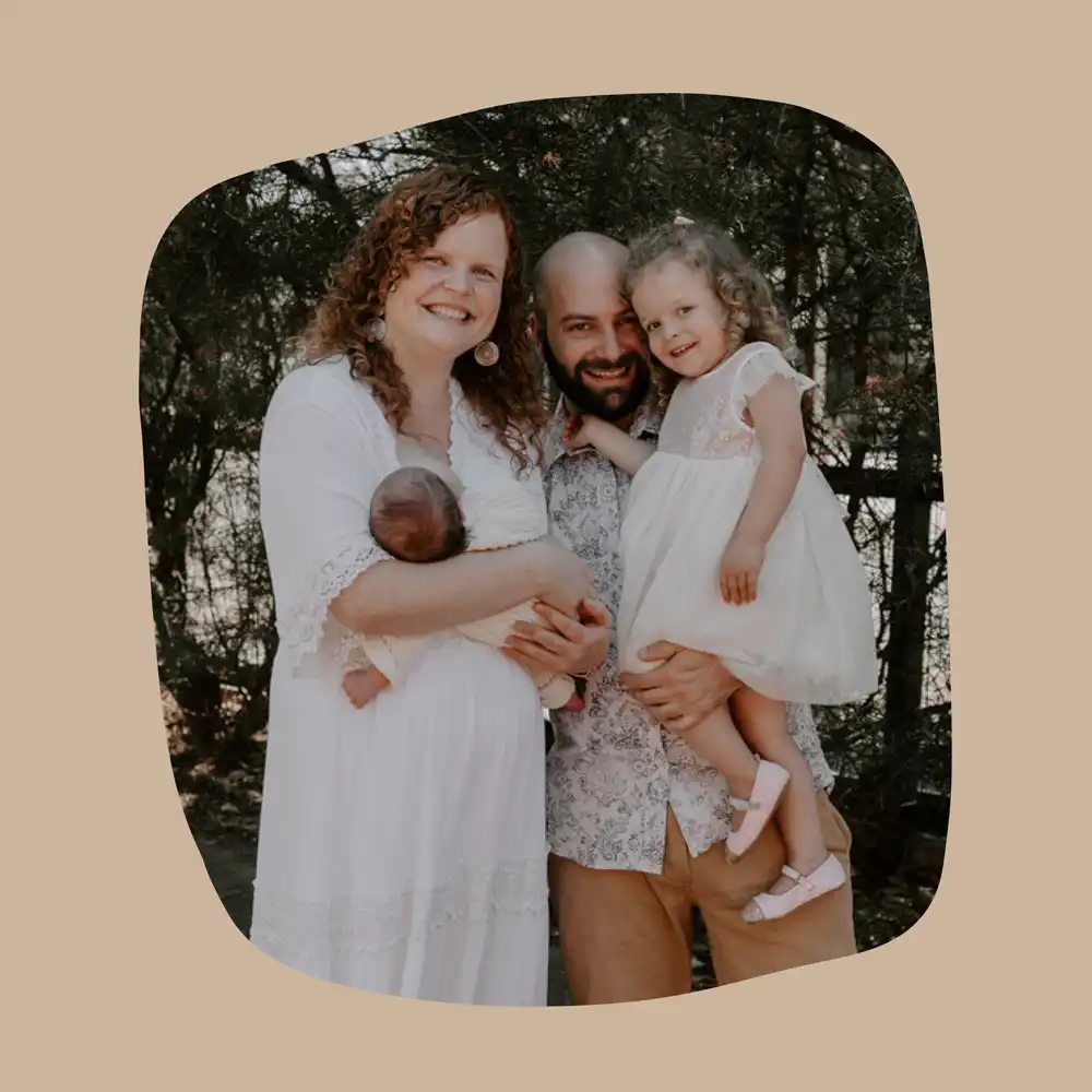 Laura poses for a photo with her husband and two children.