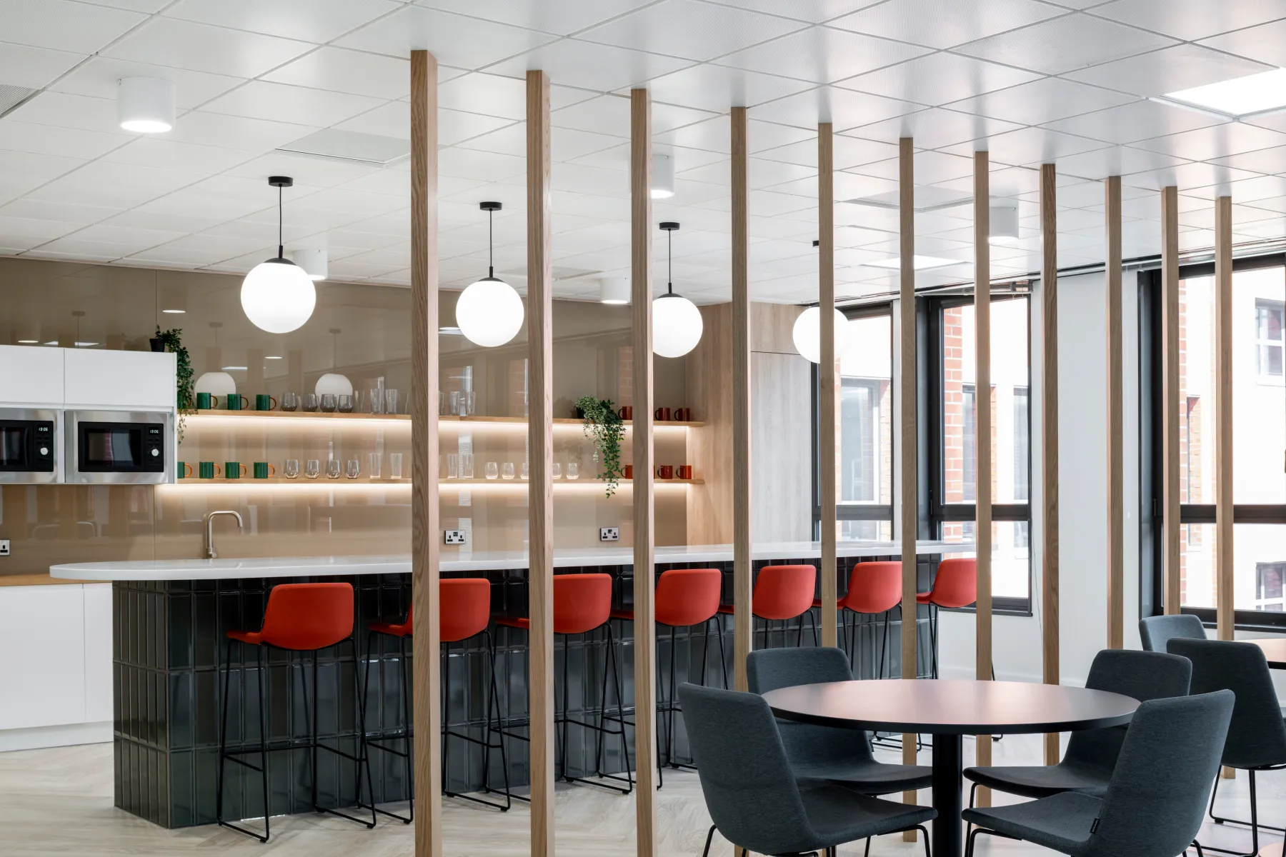 Modern wood pillars divide an office with separate seating areas