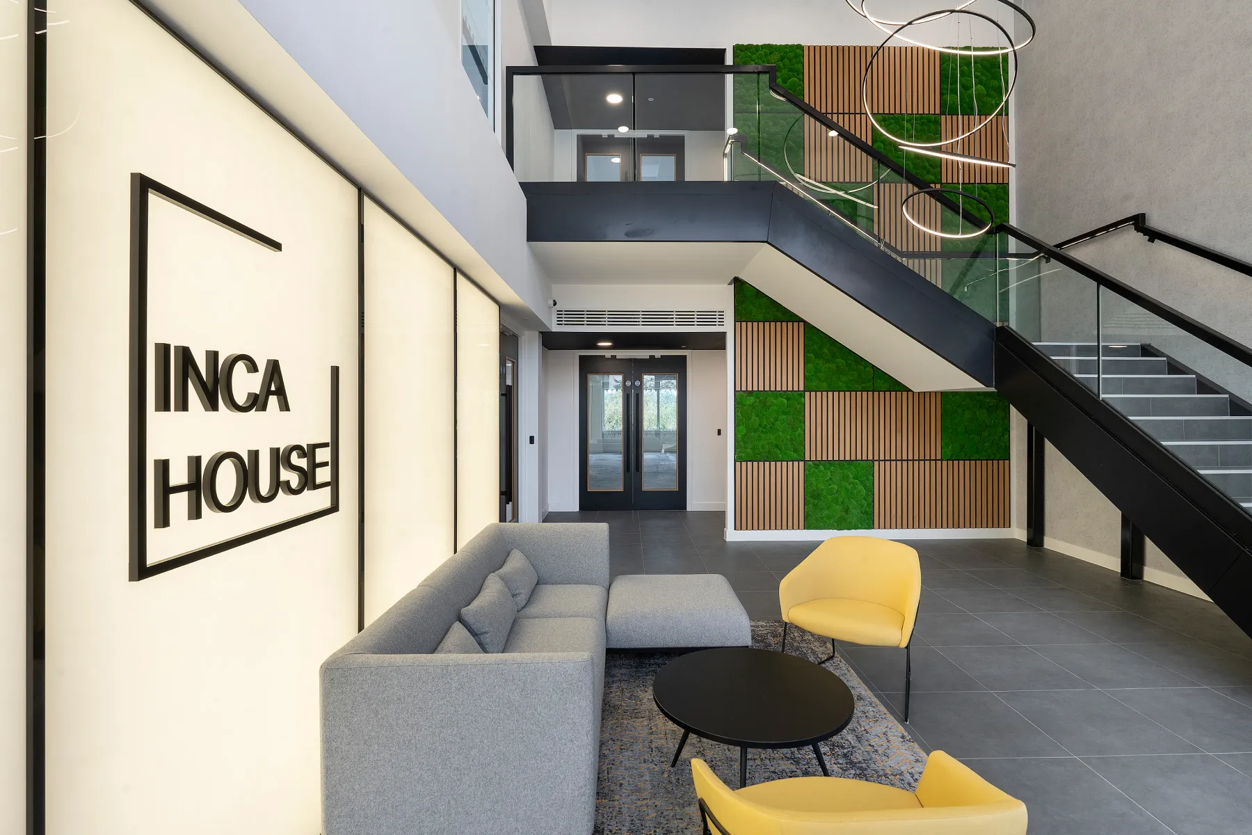 The reception area at Inca house, modern with yellow and green wall tiles and seating area.