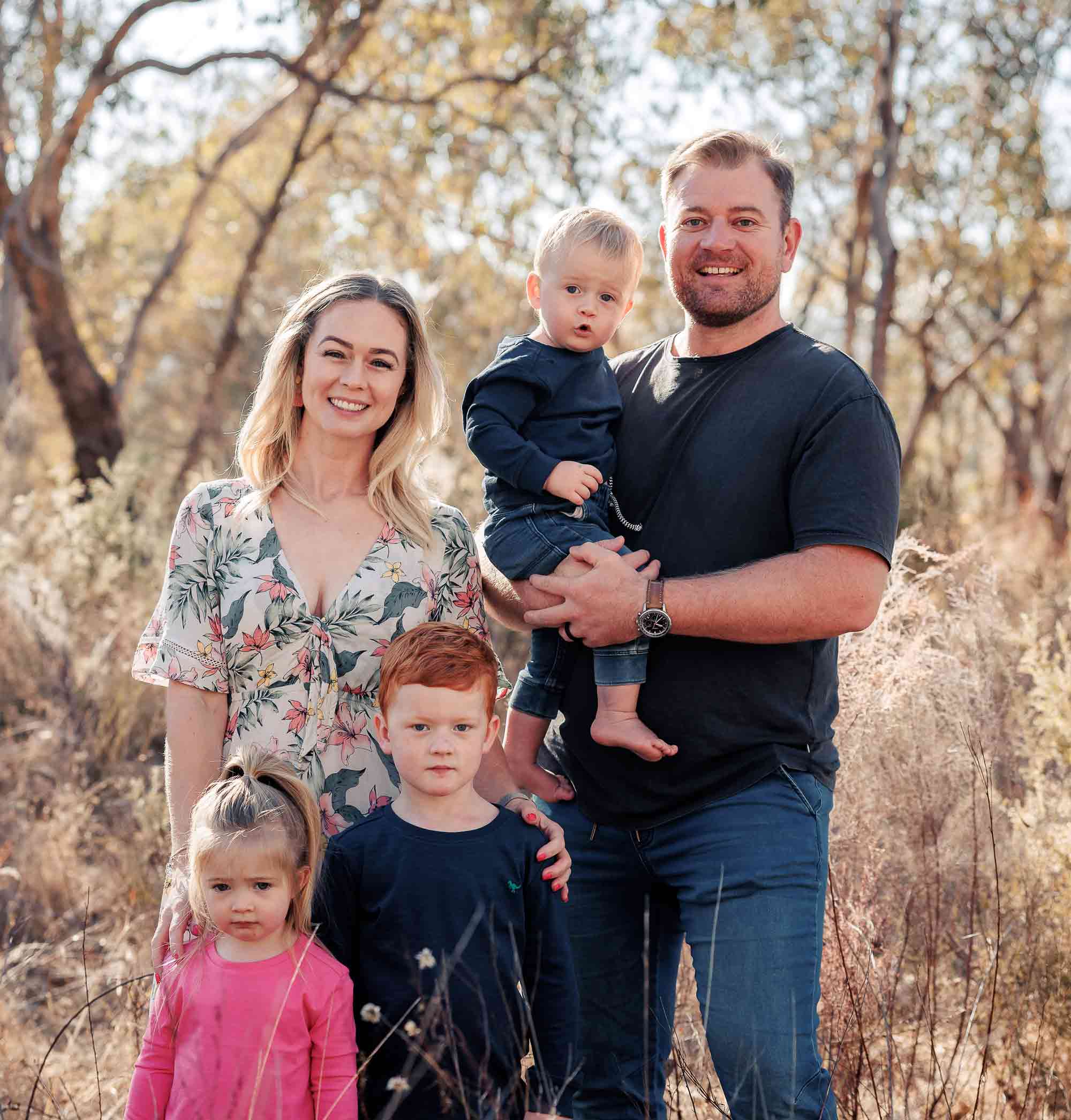Arran and his family pose for a family portrait in nature.