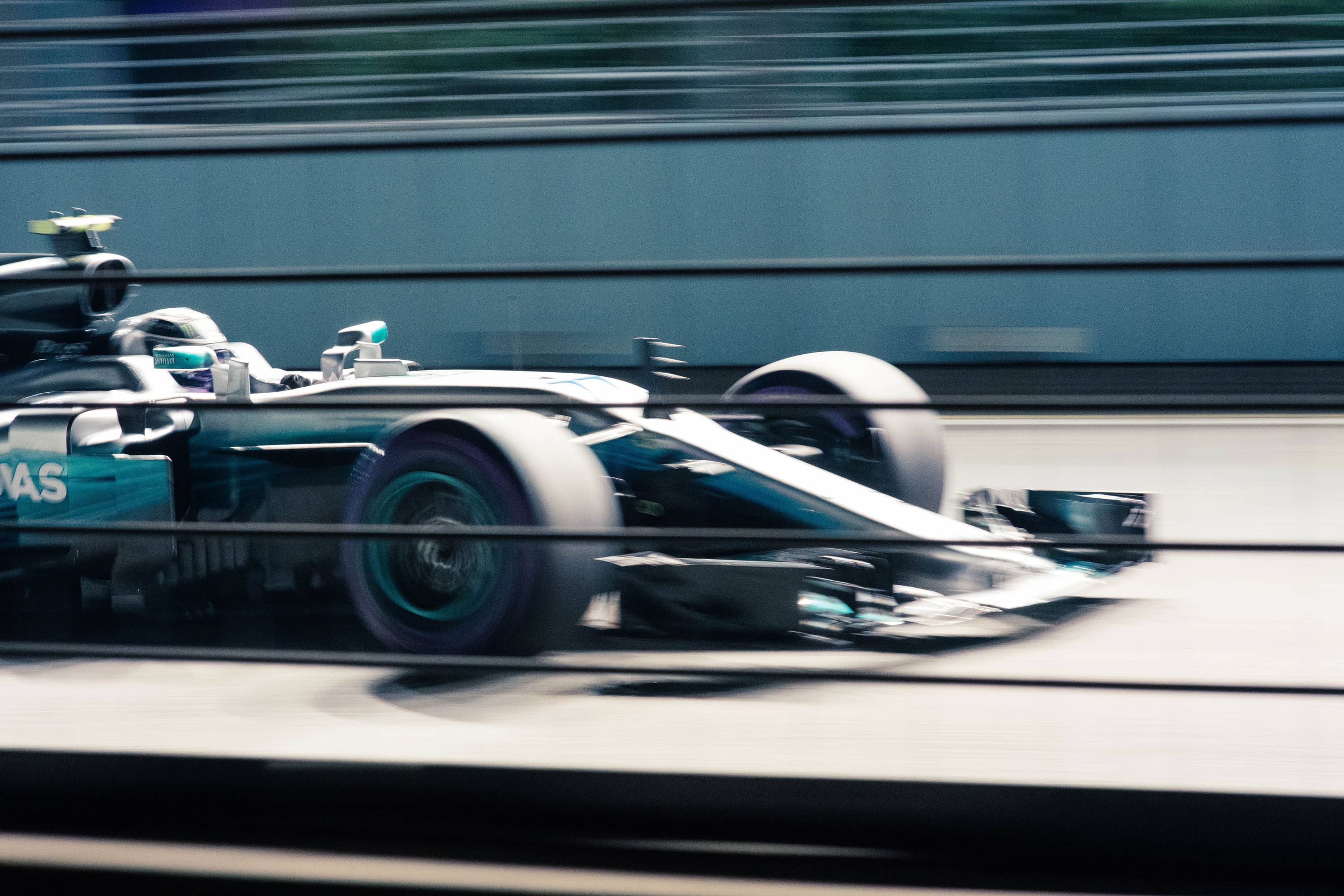 Dynamic photo of formula one race car in blue, with motion blur