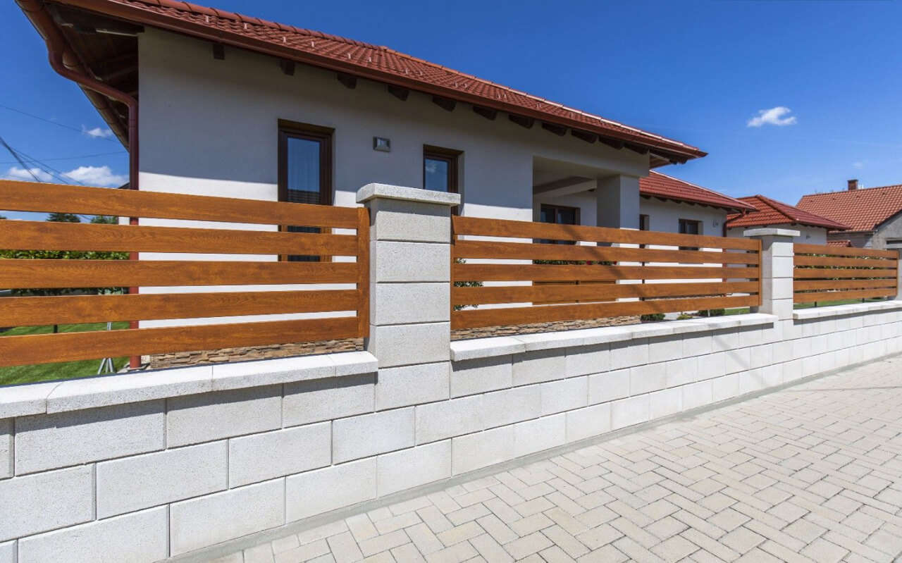 Modern fa-beton kerítés egy családi ház előtt