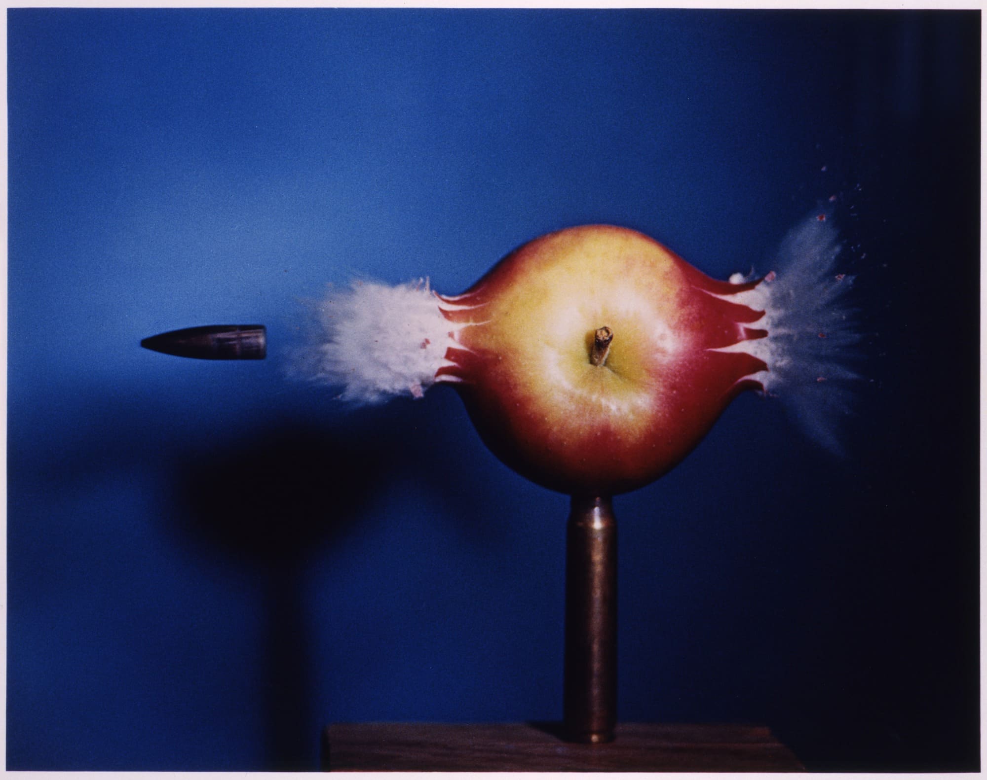 Fotografía de una bala atravesando una manzana capturada en foto ultrarrápida, una muestra de creación digital científica, tomada por Harold E. Edgerton.