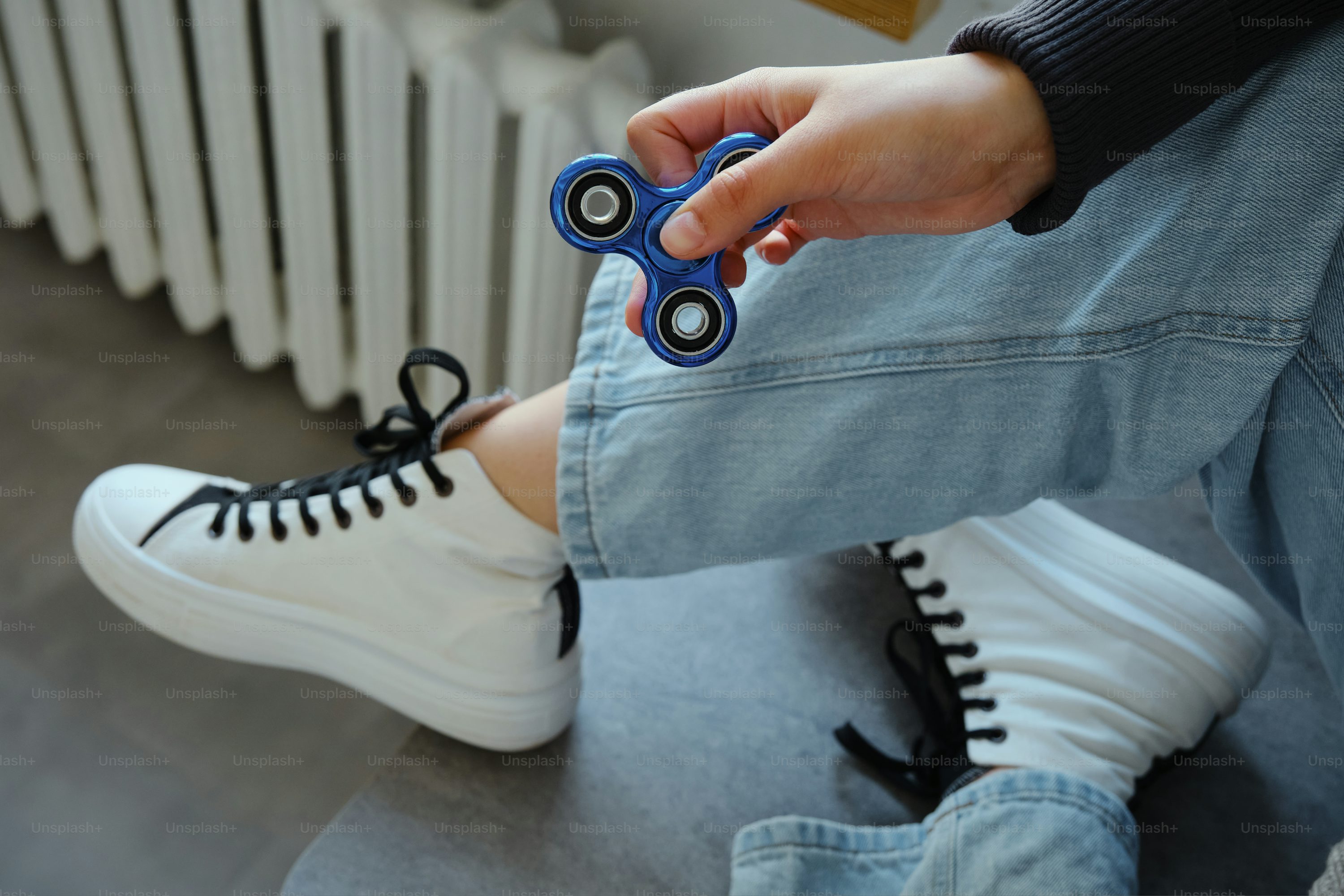 Person holding a blue fidget spinner toy