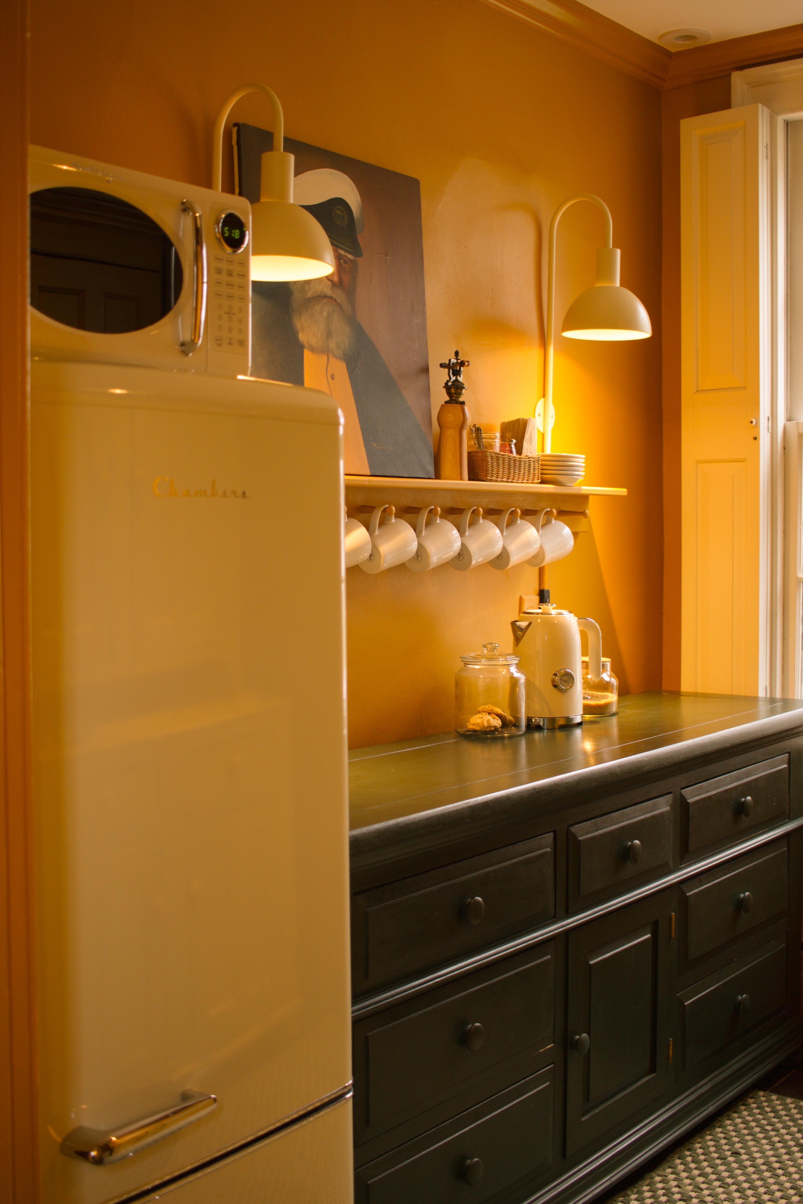 butler's pantry style room for guests with fridge, microwave, electric kettle, cutlery, glassware and plates