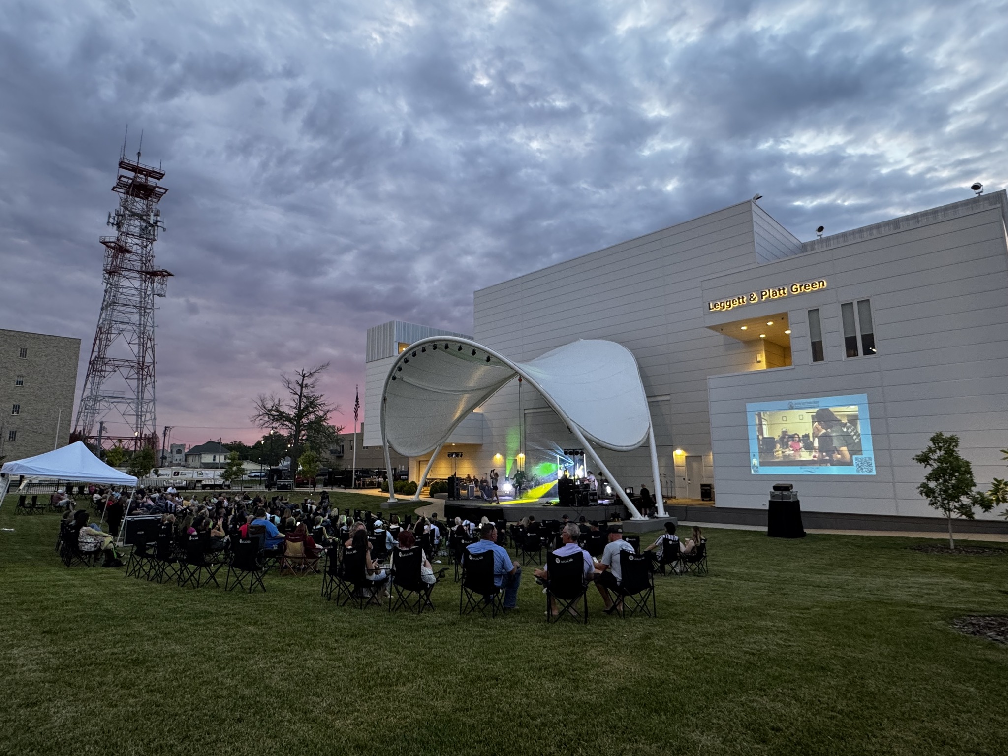 Wide shot of the Rhythm & Brews 2025 event showing the band performing on stage and guests gathered in the venue enjoying the evening.