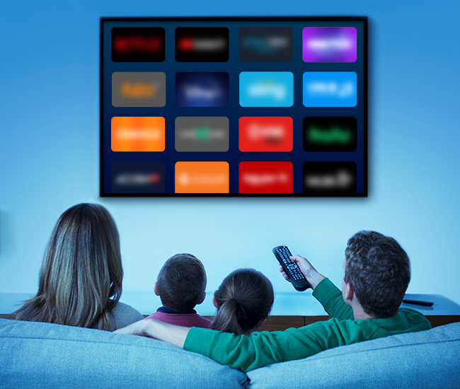 A family on the couch facing a flat screen, smart television selecting which platform to watch.