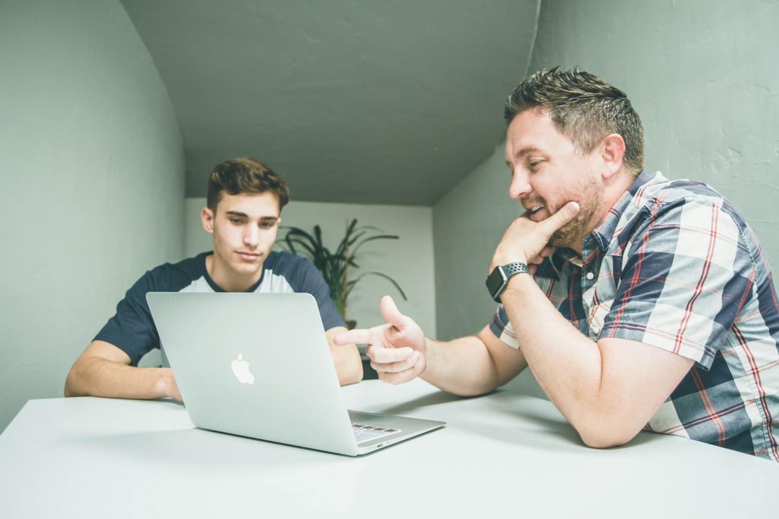Two people discussing and looking at a computer