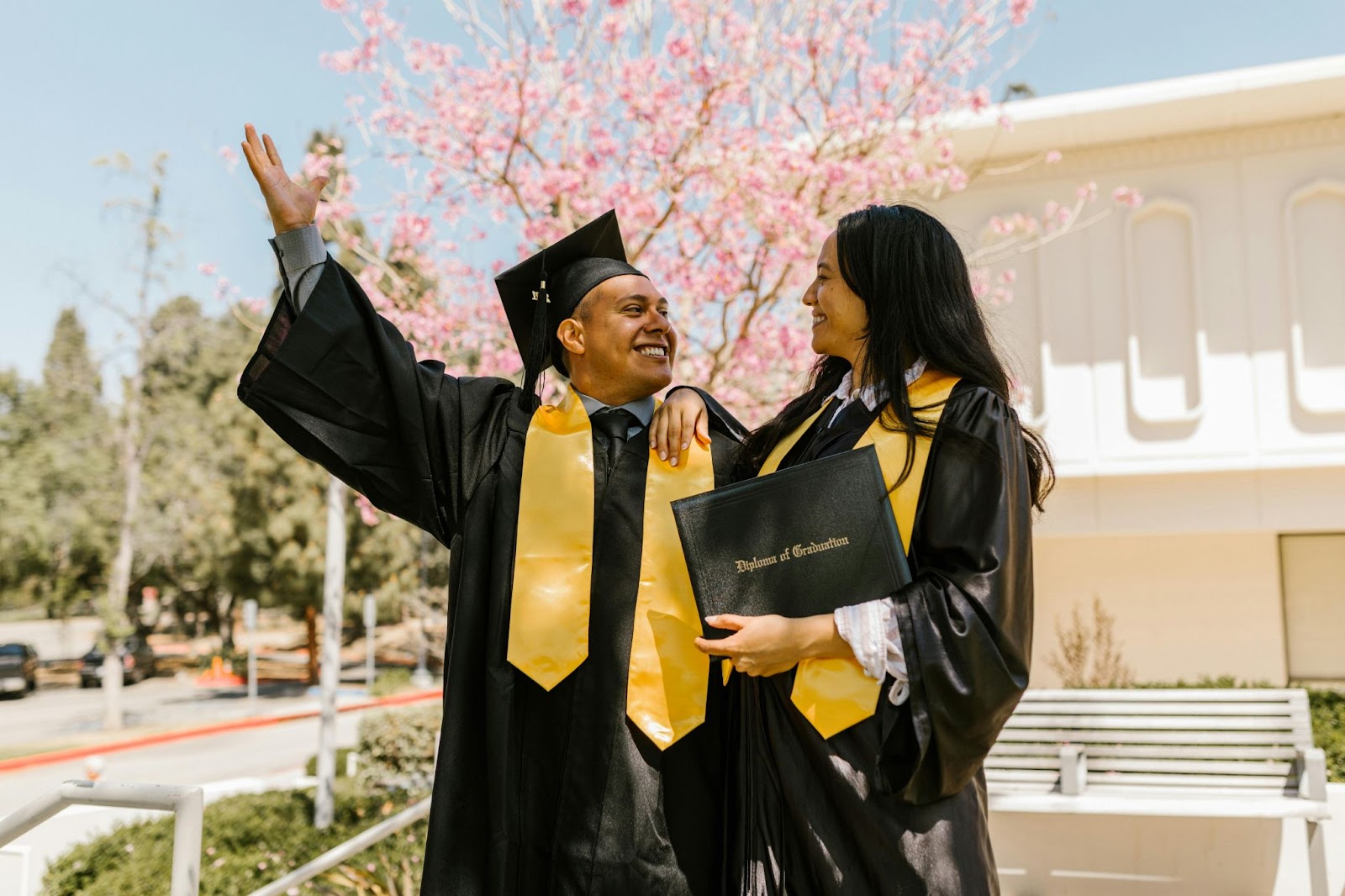 Two college graduates smiling