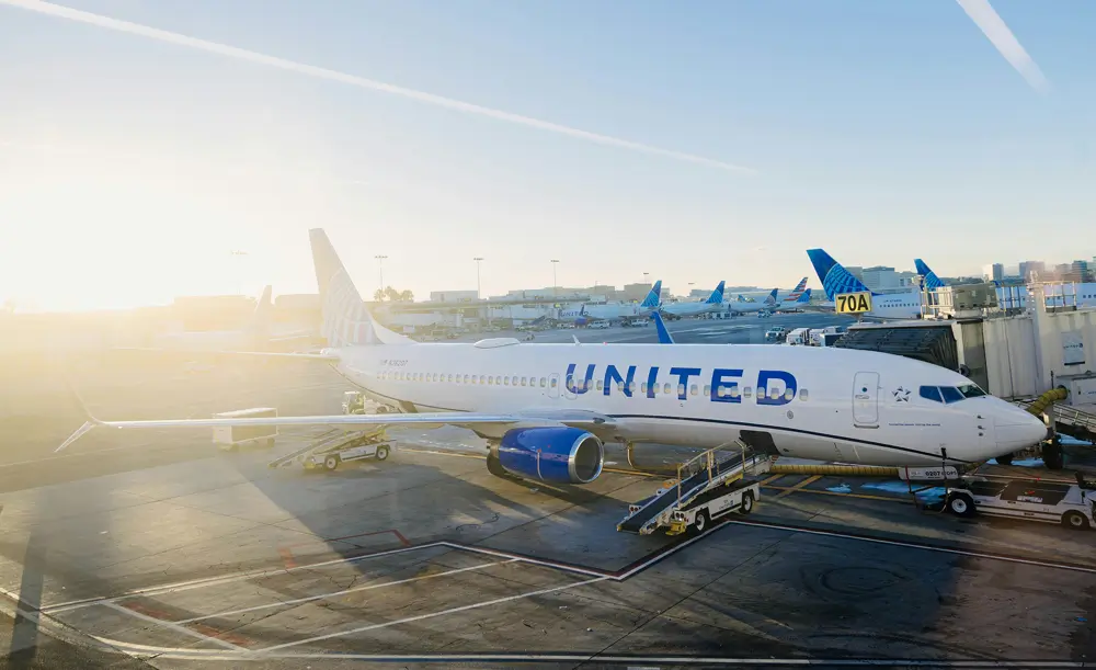United Airlines aircraft parked at an airport gate in morning sunlight