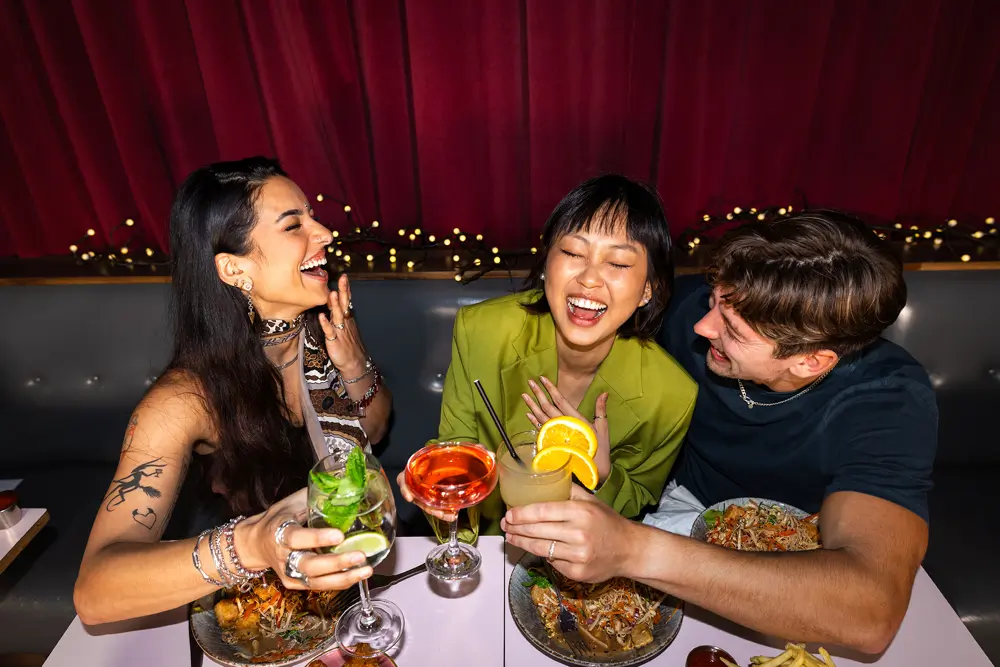 Friends laughing together over dinner and drinks at a New York restaurant