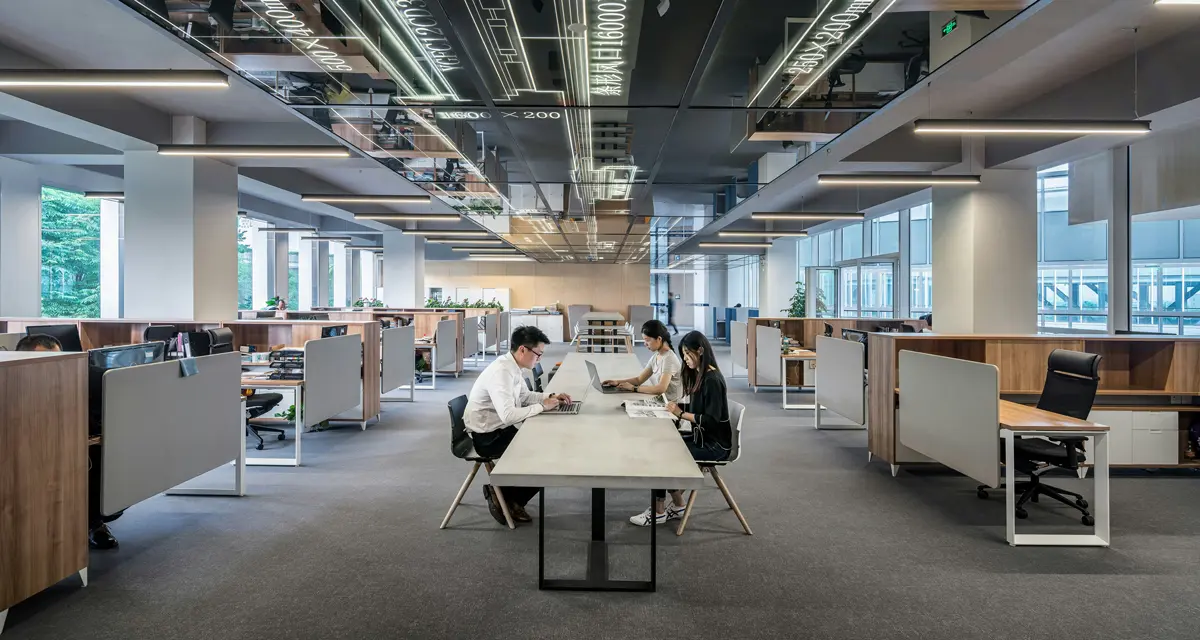Three professionals collaborating in a modern open-plan office