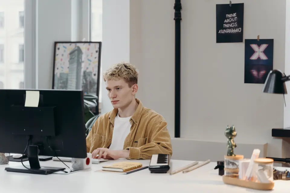 Man working at a computer in a creative workspace