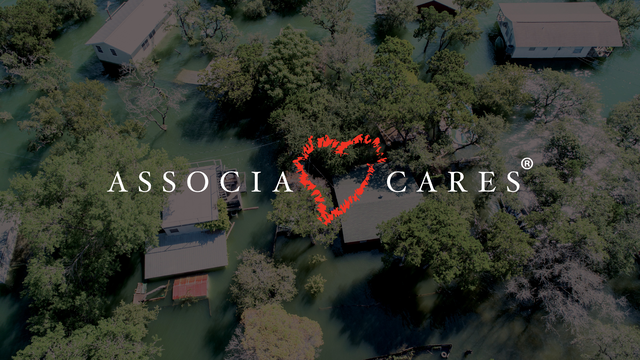 Aerial view of flooded residential area surrounded by trees, with the "ASSOCIA CARES" logo and a red heart symbol overlaid at the center. Ask ChatGPT