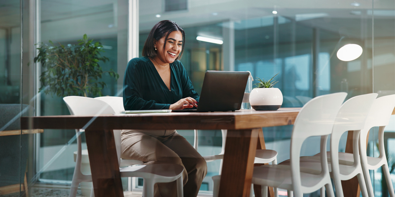 Professional woman working on a laptop in a modern office setting, representing an HOA board webinar or virtual educational event.