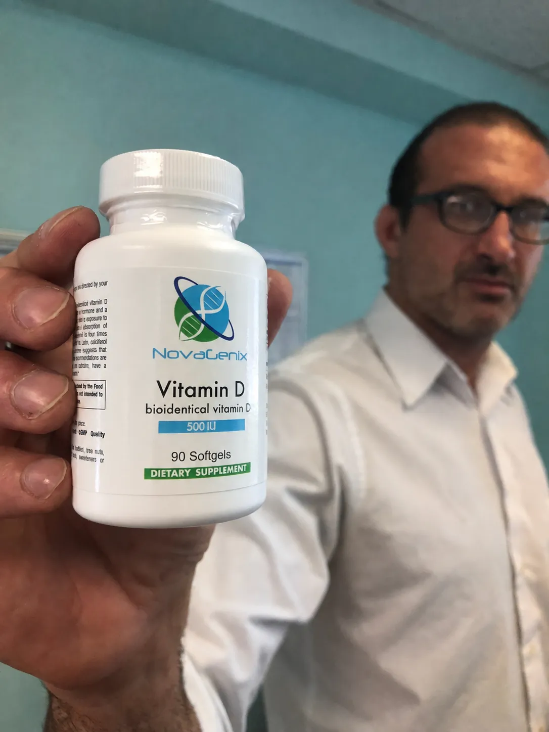 Bottle of NovaGenix bioidentical vitamin D softgels held up at the clinic in Jupiter, Florida
