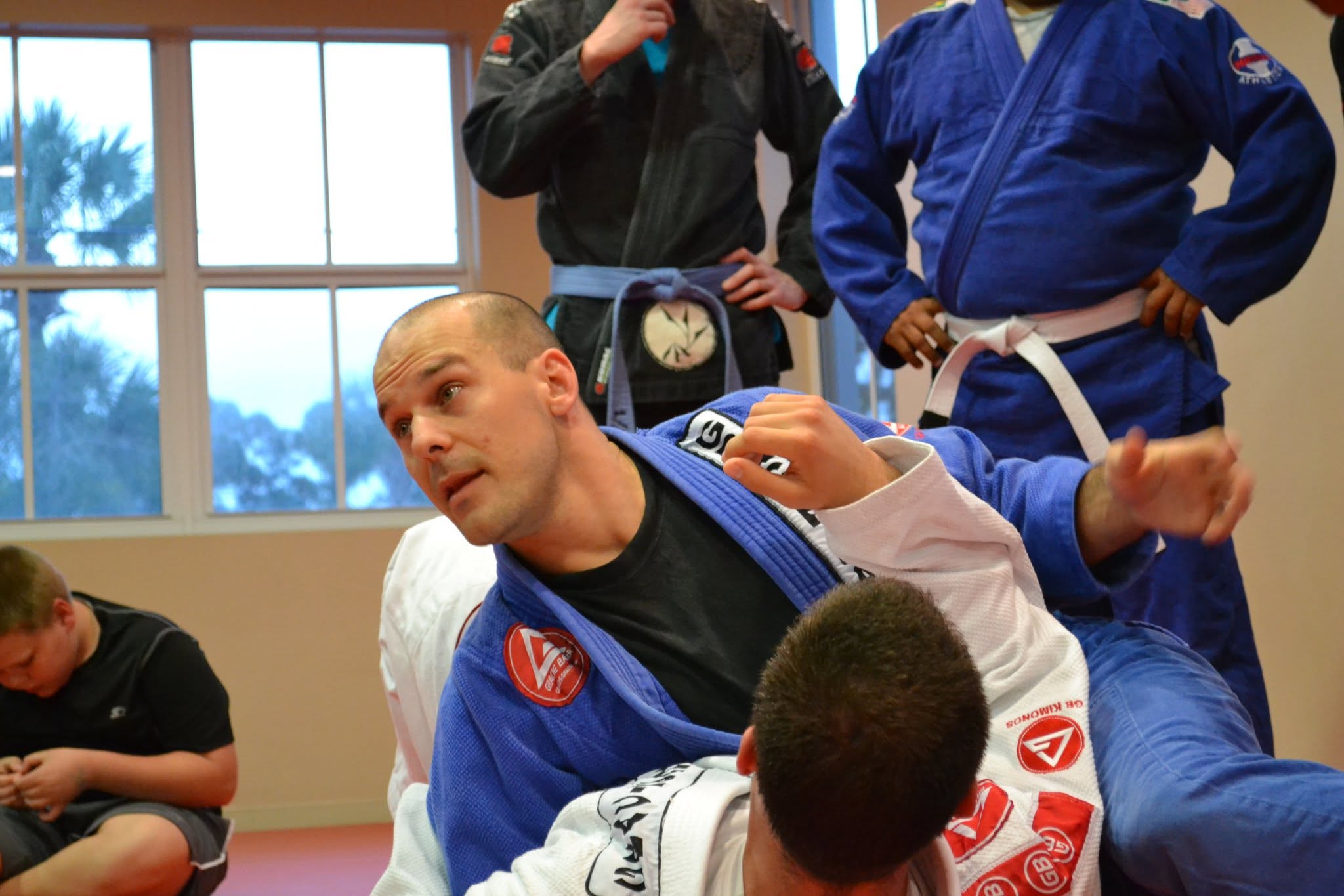 Tim Bruce demonstrating Brazilian Jiu-Jitsu on the mats in a blue gi