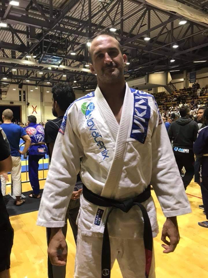 Andy Stock at a Brazilian jiu-jitsu event wearing a NovaGenix-branded gi