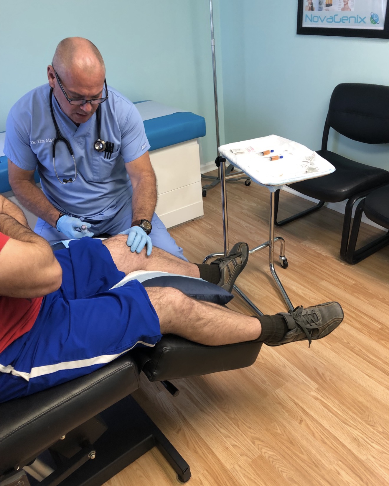 Timothy Mackey examining a patient's knee at NovaGenix in Jupiter