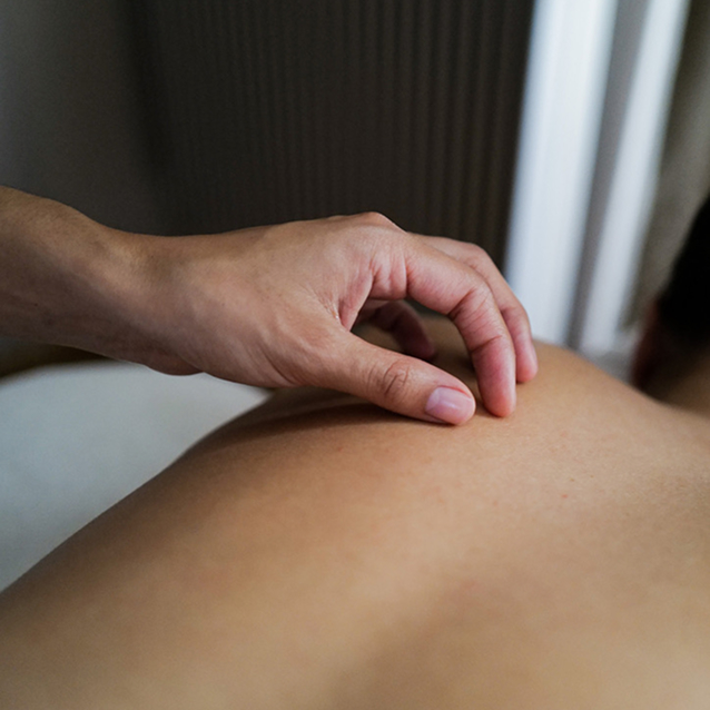 Deux mains forment un coeur au dessus d'un dos