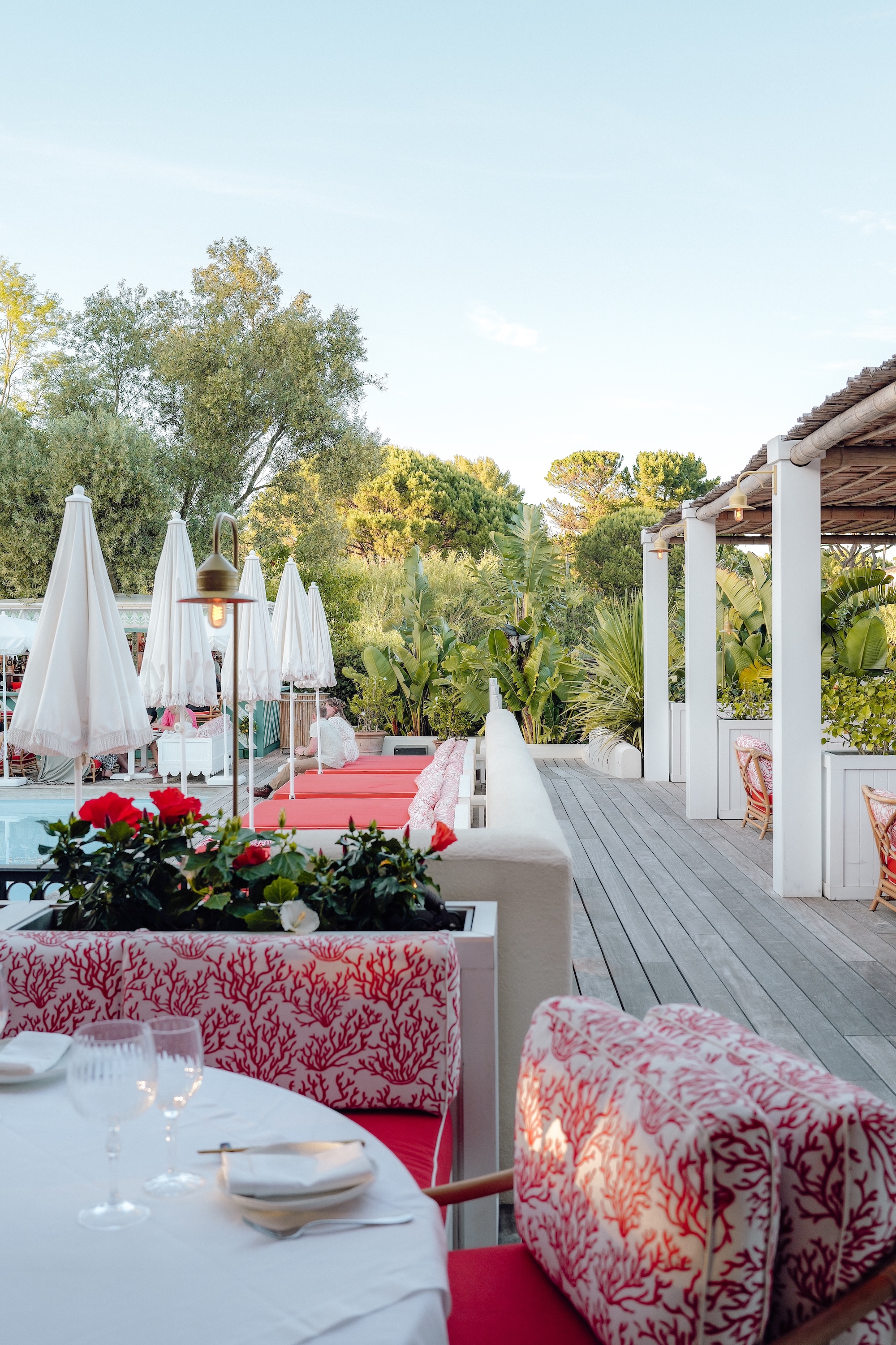 Table dressée en terrasse au coucher du soleil au restaurant Le Saint-Amour de l'hôtel La Tartane à Saint-Tropez