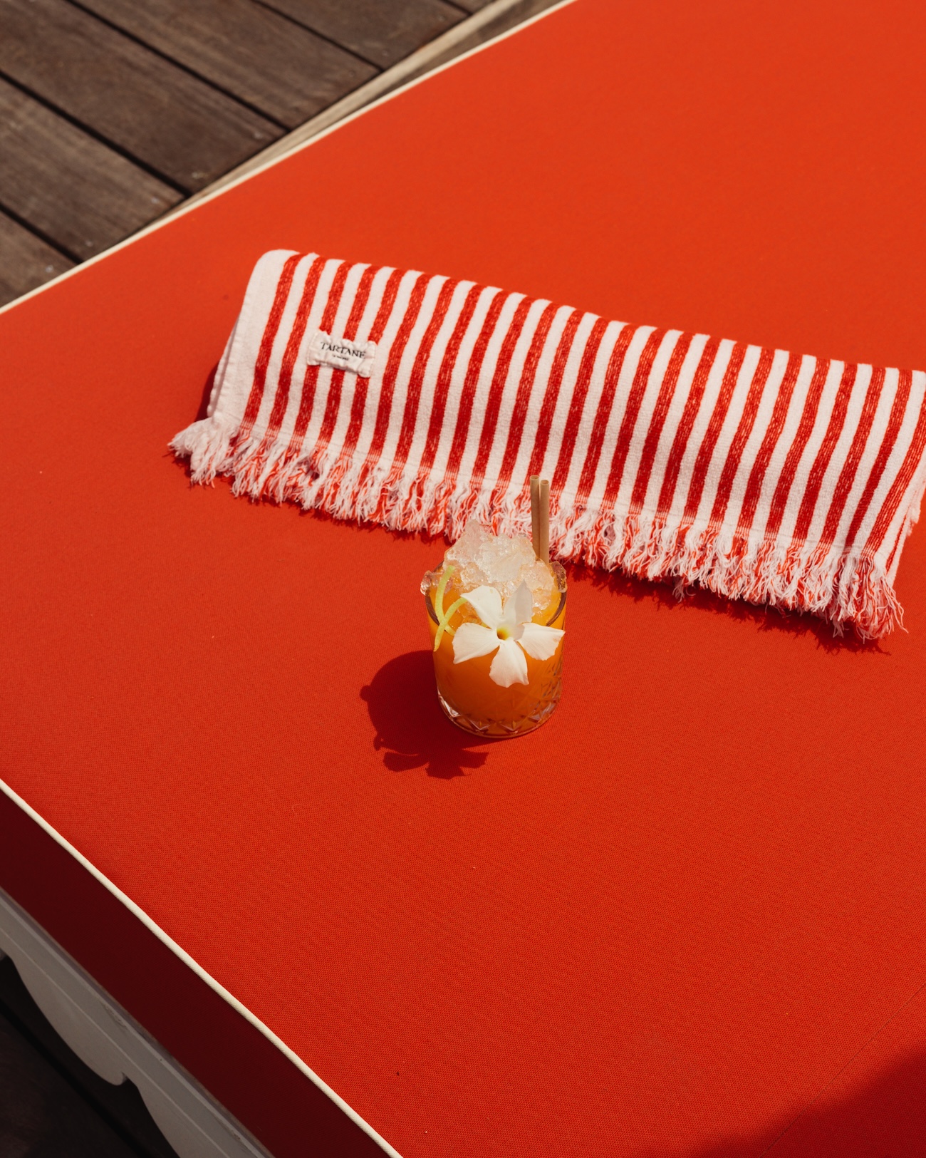 Cocktail servi au bord de la piscine de l’hôtel La Tartane à Saint-Tropez sur un transat