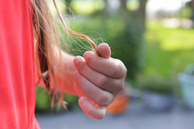 Woman holding hair in her hand