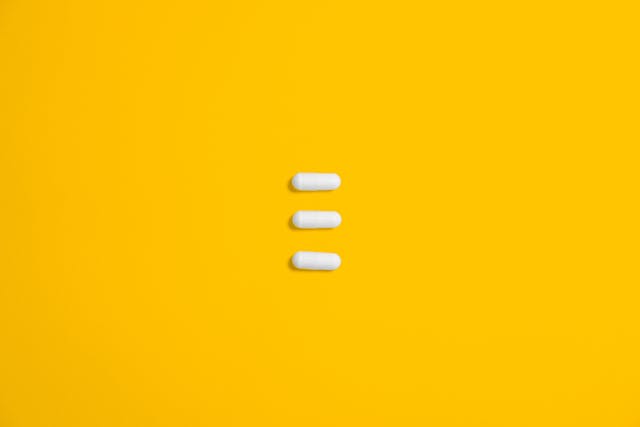 White capsules on yellow background