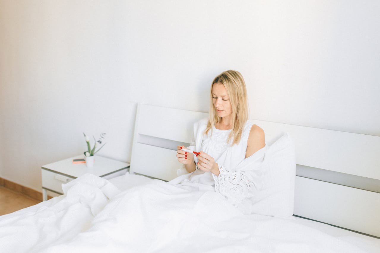 Woman Holding Pregnancy Test Lying on the Bed