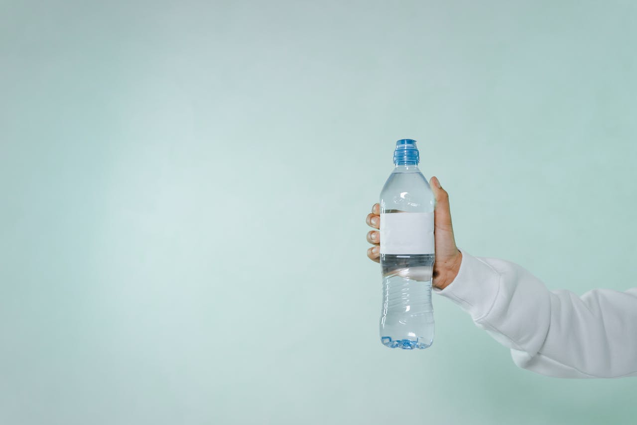 Photo of a Person's Hand Holding a Bottle of Water