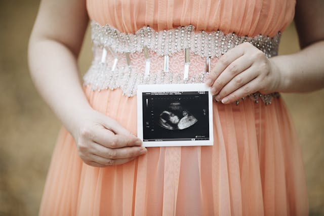 Close up on Woman Showing Pregnancy Photograph